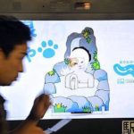 Person touching an interactive billboard in Japan