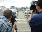 two men filming boat dock