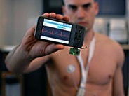 man in fitness holding heart rate monitor on iPhone