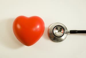plastic heart next to stethoscope