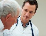 Male doctor talking to an older male patient