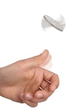Person's hand flipping a coin against white background