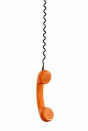 orange telephone hanging from wire