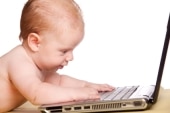 baby playing with laptop