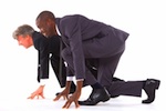 Two men wearing suits in a competitive running stance