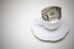 A dollar bill in an empty tea cup