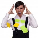 Person wearing jumper with sticky notes on them holding head in frustration