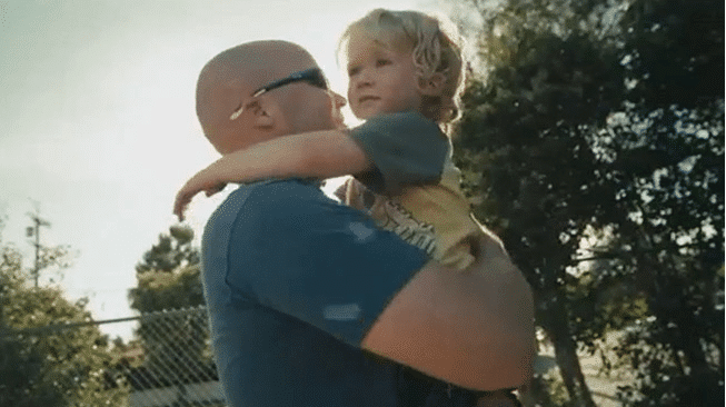 Dad standing outside holding his child in Dove Men commercial