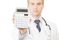 Male doctor holding up a calculator