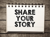 "Share your story" text on graph paper notebook sitting on wooden table