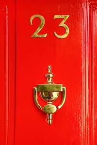 Red door with the number 23 on it in gold