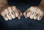 finger tattoos spelling out "hire" and "fire"