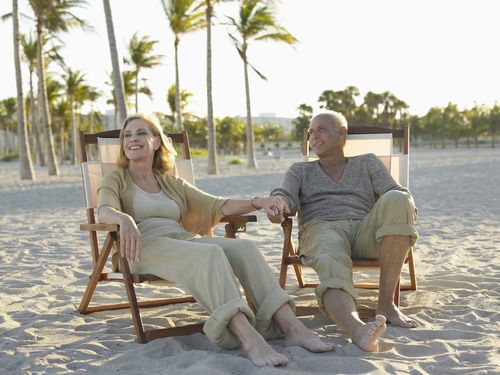 Older couple sitting together on beach chairs on the beach