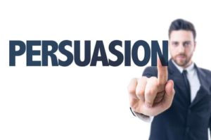 Man in suit pointing at the word "Persuasion"