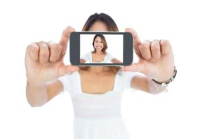 Young woman taking a selfie of herself on a smartphone