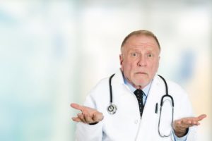 Male doctor holding hands up in confusion