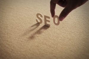 Person holding "SEO" letters