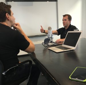 Two men having a discussion in a conference room, sitting across from each other