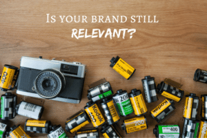 camera and camera film on desk and text reading "Is your brand still relevant?"