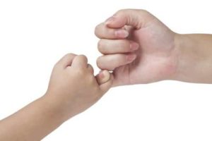 Child and adult pinky promising against white background
