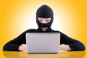 Person in mask looking at laptop