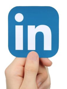 Hand holding a LinkedIn logo
