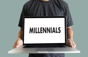man holding laptop with text reading "millennial"