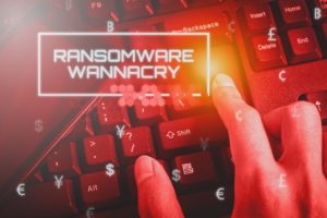 Person typing on keyboard with "Ransomware wannacry" text displayed