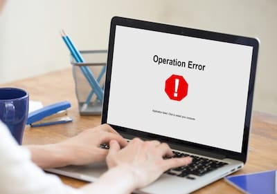 Person using a laptop displaying an "Operation Error" on screen