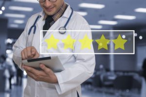 Smiling doctor checking an online five star review on iPad