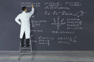 Doctor standing on ladder writing equations on a giant chalk board