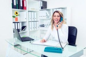 a medical scheduler on the phone in her office