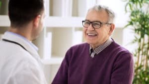 Older man conversing with doctor